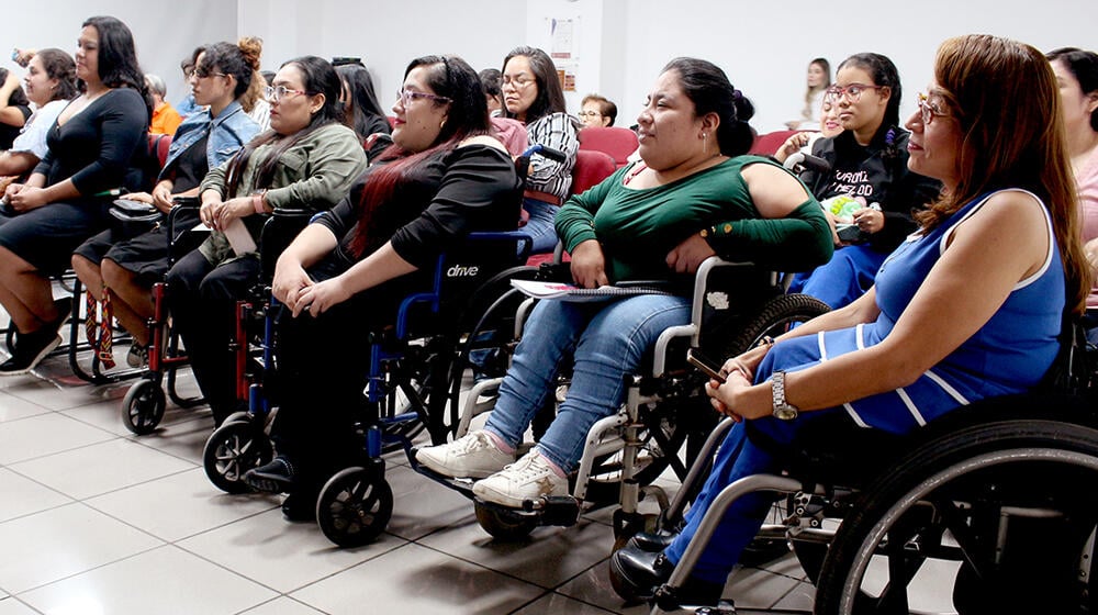 Personas con discapacidad, en silla de ruedas, participan en un acto de clausura de un proceso formativo realizado por UNFPA.